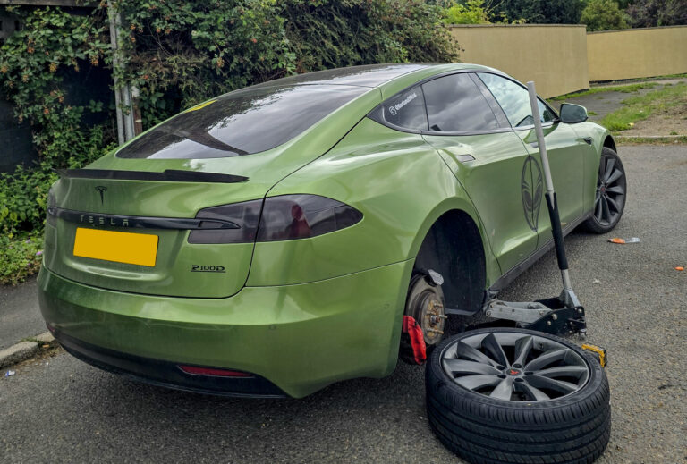 Mobile tyre fitter fitting new wheel with specialised tools.