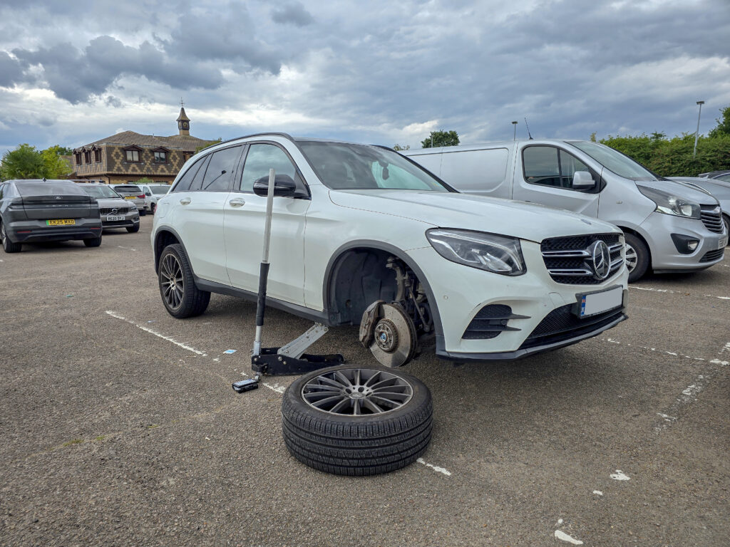 Mobile tyre fitter fitting new wheel with specialised tools.
